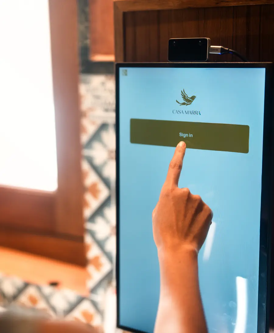 A member taps Sign in on the Lumis terminal at Casa Marra